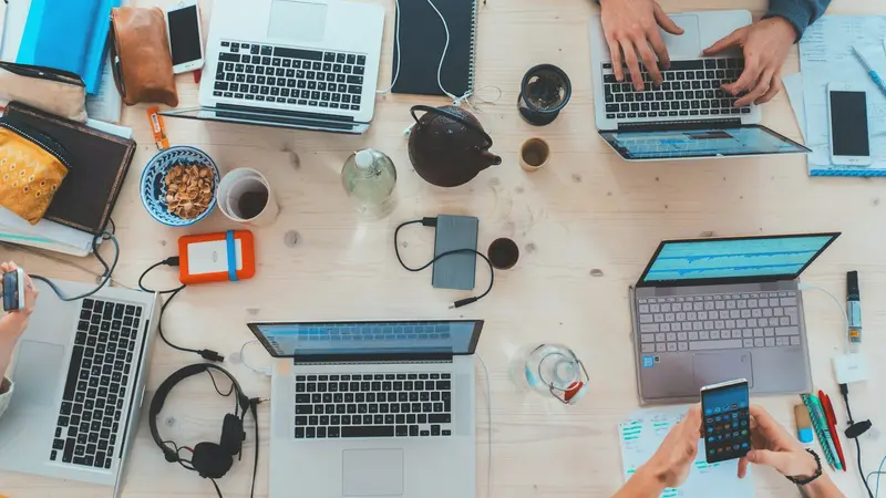 Laptops and notes across a shared table