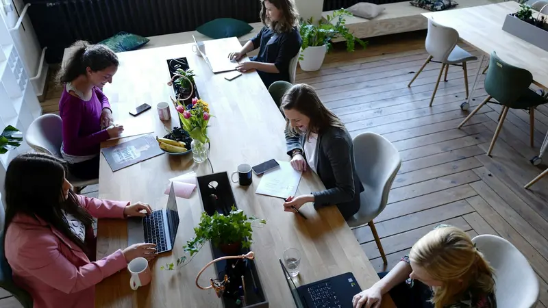 A long table of people at work