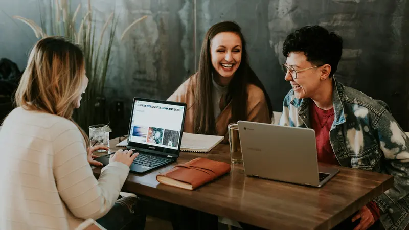 Three colleagues around a laptop